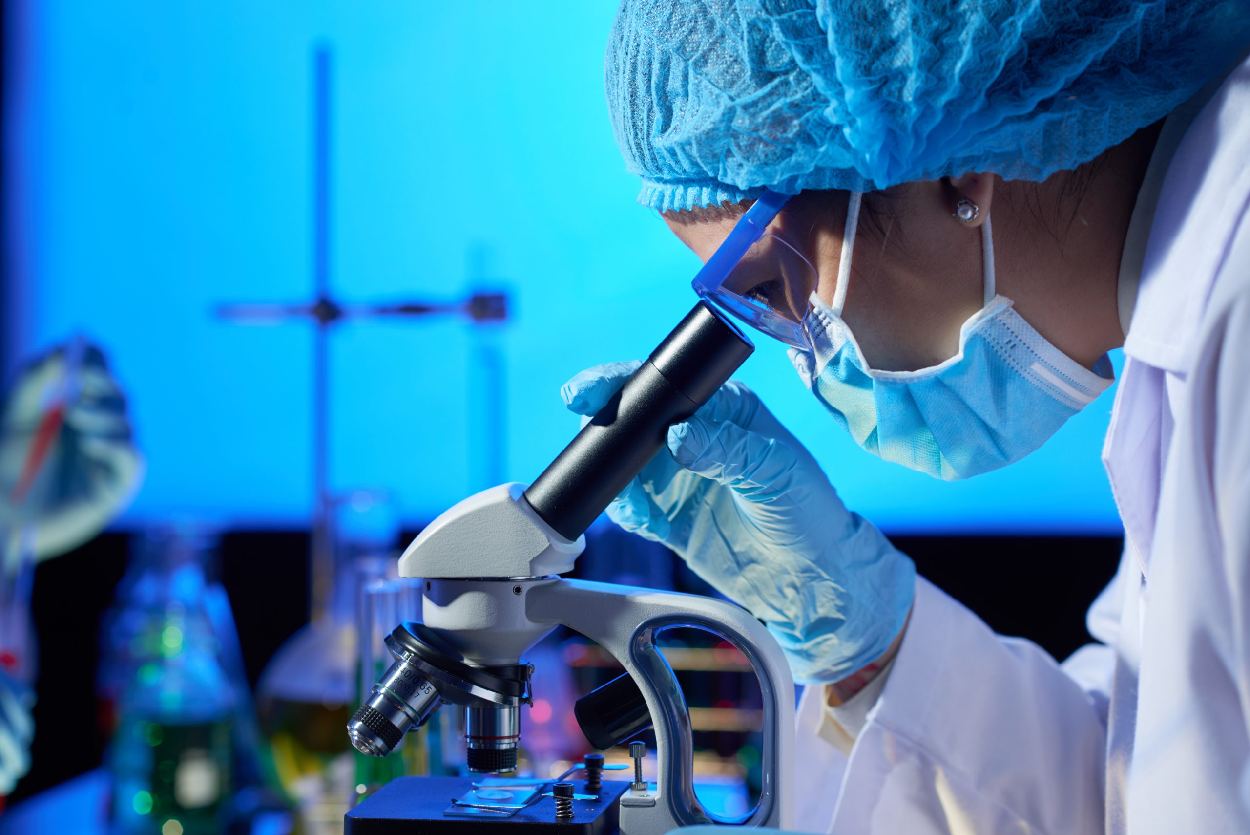 Técnico de laboratorio usando muestra de CBD (cannabinoides) en microscopio